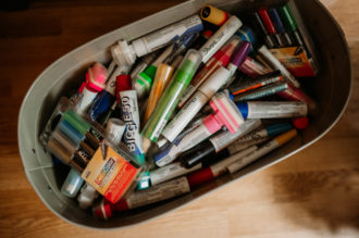 metal bucket filled with a variety of drawing markers